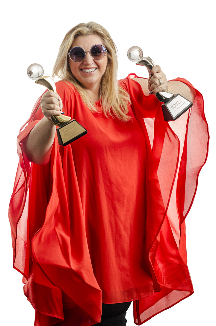 Lorraine Simpson holding two international travel awards